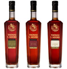 three bottles of thomas s moore's bourbon whiskey are shown in this image, one is red and the other is orange