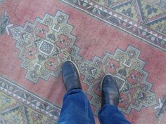 a person standing on top of a rug with their feet propped up against the carpet