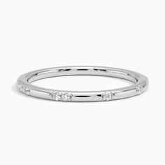 a white gold wedding band with five diamonds on the side, set in 18k white gold