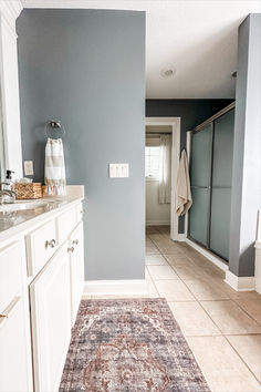 a bathroom with blue walls and white cabinets