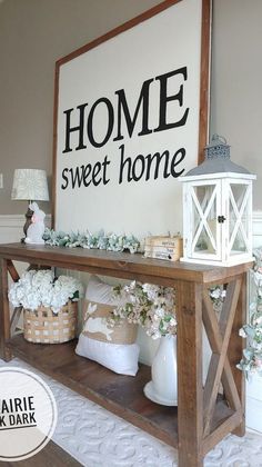 a wooden table topped with baskets filled with flowers next to a sign that says home sweet home