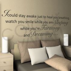 a bedroom with a bed, nightstand and wall decal that says i could stay awake just