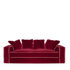 a red velvet couch with four pillows on it's back and one arm facing the camera