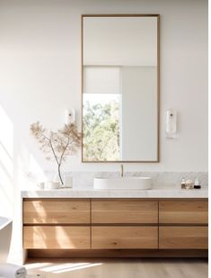 a bathroom vanity with a large mirror above it