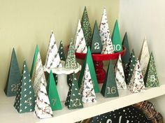 christmas trees are sitting on a shelf next to a clock