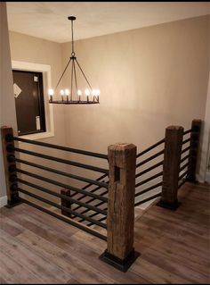 a chandelier hanging from the ceiling above a wooden railing with candles on it