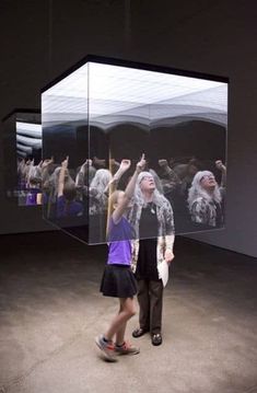 two people standing in front of a glass display