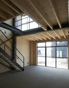 an empty room with some stairs and windows