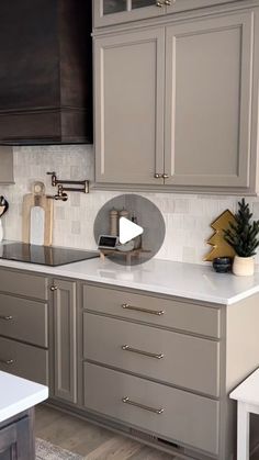 a kitchen with gray cabinets and white counter tops