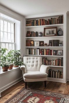 a white chair in front of a bookshelf filled with lots of books and plants