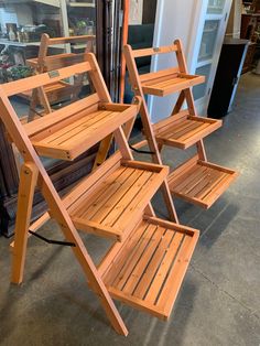 two wooden benches sitting next to each other in front of a store window with glass doors