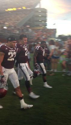 two football players are walking on the field