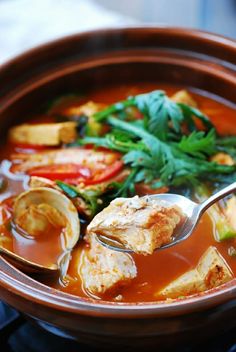 a bowl filled with soup and vegetables on top of a stove