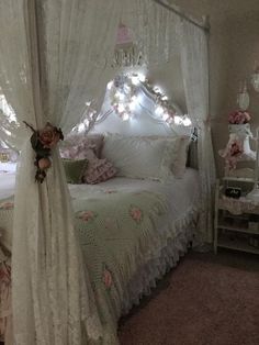 a white bed sitting in a bedroom next to a table with flowers on top of it