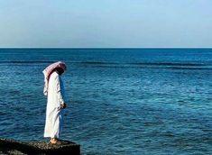 a person standing on a rock near the ocean