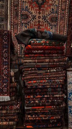 many rugs are stacked on top of each other