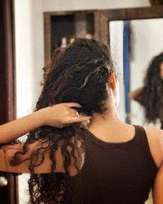 a woman is drying her hair in front of a mirror