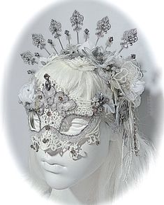 "This opulent masquerade mask is white & silver with lace overlays and beaded appliques that cascade from the crown. The lace mask is painstakingly loaded with beads, gems, vintage trims and silver accents. Photographing the sparkle is almost impossible but it is very sparkly in person! Organdy flowers and ropes of beads are featured on each side. Rhinestones, and silver filigree metal work and drops add elegant touches. There is a gorgeous rhinestone chain on elastic ends to wear this mask. Full Face Silver Masquerade Mask, Silver Full Face Masquerade Mask, Silver Full Face Mask For Masquerade, Elegant White Masquerade Mask For Carnival, Fantasy White Wedding Headpieces, White Fantasy Wedding Headpieces, White Full Face Mask For Masquerade, Elegant White Masquerade Mask For Mardi Gras, Elegant White Eye Mask