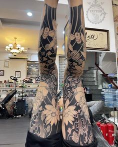 the legs are covered with tattoos and flowers