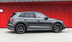 the new audi q3 is parked in front of a red wall and black rims