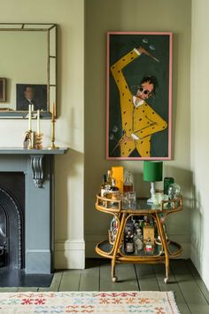 a living room filled with furniture and a painting on the wall above a fire place