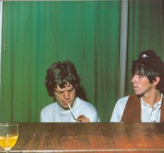 two men sitting at a table with drinks