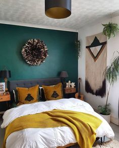 a bedroom with green walls and yellow pillows