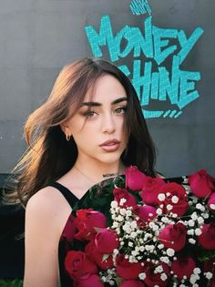 a woman holding a bouquet of red roses