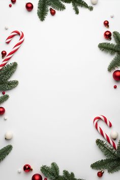 candy canes and christmas decorations on a white background with copy - space in the center