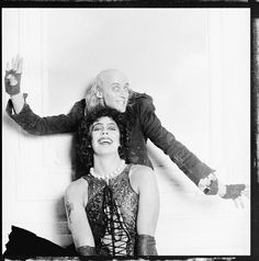 an old black and white photo of two people dressed as dracula and the woman is sitting on her head