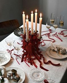 a table topped with plates and glasses filled with candles