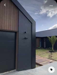 two garages with one door open in front of the other, and another building behind them