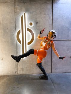 a woman in an orange outfit is dancing