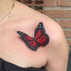 a woman's shoulder with a red butterfly tattoo on her left shoulder and chest