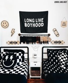 two twin beds with black and white bedding in a room decorated with wall hangings