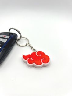 a car keychain with a red and white cloud on it's side