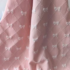 the pink fabric has white bows on it