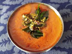 a metal bowl filled with food on top of a blue table cloth