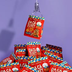 a pile of tasty looking snacks hanging from a hook on a purple wall with the tag daca tuye