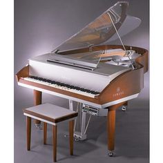 a grand piano sitting on top of a wooden table next to a stool and foot stool