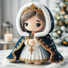 a crocheted doll wearing a blue and white dress with a gold tiara