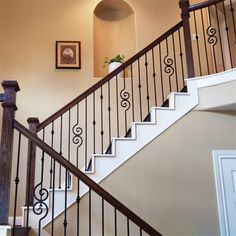 a stair case next to a framed photograph on the wall and a potted plant