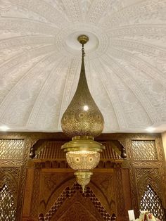 an ornate chandelier hanging from the ceiling in a room with white walls and ceilings