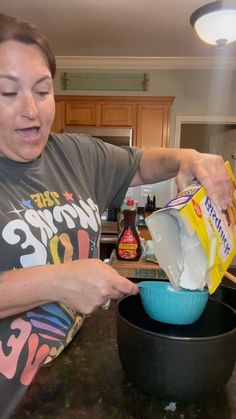 a woman is pouring something into a blue bowl