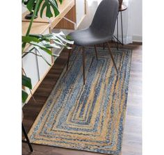 a blue and yellow area rug with a chair in the corner next to a plant