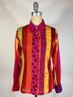 "Check out this colorful, pattern-FUL, one-of-a-kind button down shirt! This fabulous shirt, originally designed by Alpana Bawa, has been lovingly re-done with a 'creative repair': as an ode to patterns, each panel has a different theme print that has been hand-drawn. This is a classic, light-weight woven cotton button-down shirt with full length sleeves and flat, real shell, carved buttons. Marked size Large. The patterns/prints are as follows: Front right; polka dot, brick, wood grain, cross-hatchery, beaded curtain & paisley Right cuff features gingham Back right; paisley, static/scribbles, sunbursts, plaid, checkered, vine & animal print Back left; citrus fruits, pebbles, Greek key, time + space, ditsy & zipper Left cuff features houndstooth Front left; curly-q's, cascading hair, honey Multicolor Long Sleeve Shirt With Button Closure, Fun Multicolor Long Sleeve Shirt, Multicolor Long Sleeve Shirt With Graphic Print, Multicolor Long Sleeve Shirt With Buttons, Multicolor Cotton Blouse With Buttons, Multicolor Print Cotton Shirt For Fall, Casual Multicolor Blouse With Unique Print, Colorful Patterned Shirt For Fall, Vibrant Multicolor Printed Shirt