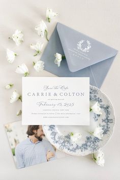 the wedding stationery is laid out on top of an envelope, with white flowers