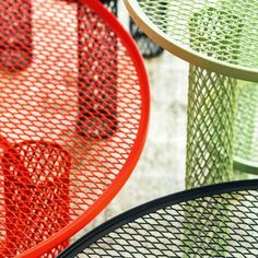 three round tables with different colors and patterns on top of each table, one is red