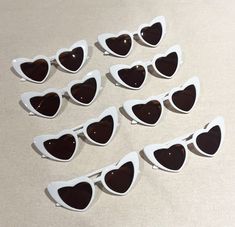 six pairs of heart shaped sunglasses sitting on top of a table