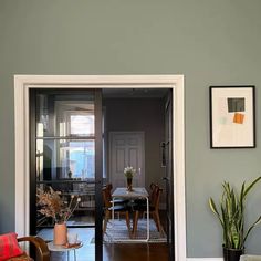 a living room filled with furniture next to a dining room table and potted plants